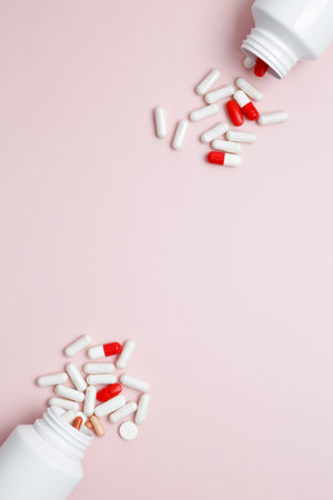 Concept of healthcare and medicine. White bottles container with colorful medication capsules and tabletsの写真素材