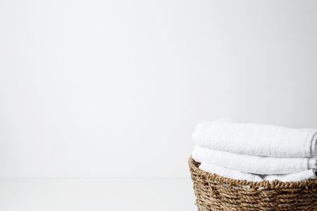 Basket filled with clean white towels in a neat arrangement. Household cleaning and hygiene concept concept packagingの写真素材