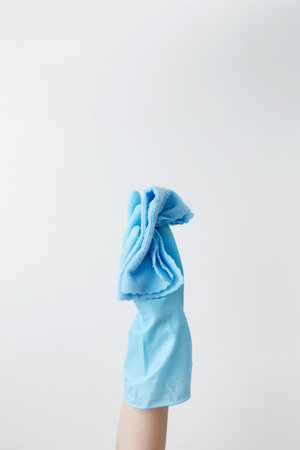 Blue cleaning products, the woman cleans using rubber gloves and a microfiber cloth. Household cleaning and hygiene conceptの写真素材