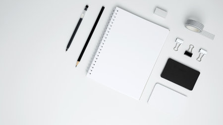 Monochrome stationery items. On a white background, an empty mock up notebook, white and black cardsの写真素材