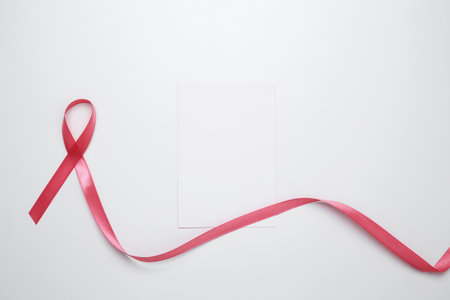 Pink ribbon on white card for breast cancer awareness and prevention reminderの写真素材