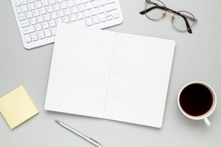 Organized workspace with stationery, keyboard, glasses and notebook creating a productive atmosphere