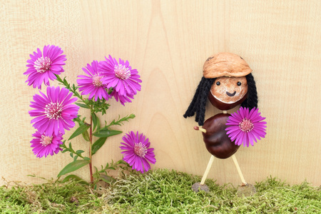 Smiling chestnut figure with autumn flowersの写真素材