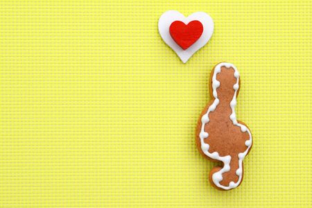 Music creative composition with gingerbread treble clef on bright yellow background, copy space for...