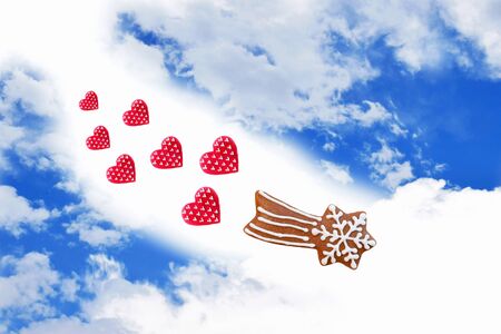 Creative composition with gingerbread comet and red hearts on blue skyの写真素材