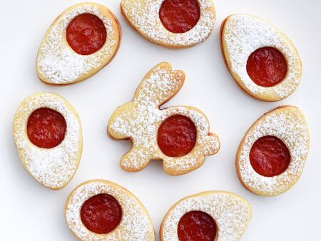 Linzer cookies in Easter shapes, filled with jam and sprinkled with powdered sugarの写真素材