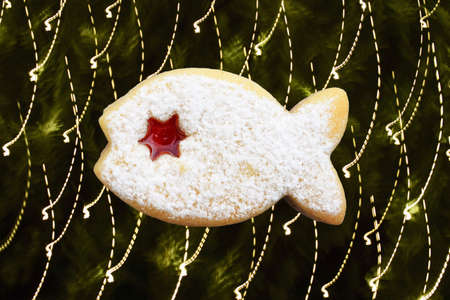 Romantic christmas concept - linzer cookie in a shape of fish isolated on background with light effectの写真素材