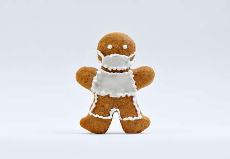 Gingerbread man with protective face mask, white background.
