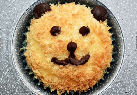 Cute bear muffin - homemade coconut muffin decorated with chocolate like a bearの写真素材