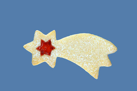 Linzer cookie in a shape of comet filled with strawberry jam. Isolated on blue backgroundの写真素材