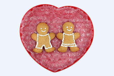 Heart with smiling gingerbread man and woman, isolated, copy space. Love concept, Valentine's day