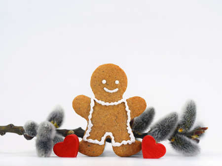Smiling gingerbread man, willow twig and two red heart. Romantic spring, Easter or love composition....
