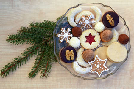 Several kinds of Christmas cookies on a glass plate, spruce twig decorationの写真素材