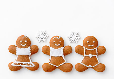 Happy gingerbread family on a white background with snowflakes