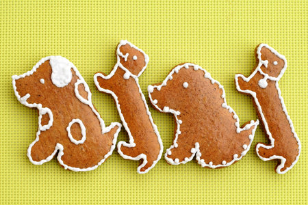 <p>Gingerbread dogs decorated with white icing, bright yellow background</p>の写真素材
