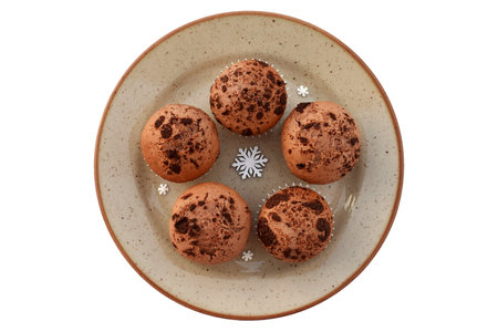 Delicious homemade cocoa muffins with chocolate on a plate, winter decoration aroundの写真素材