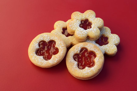 Linzer cookies on a red background, flowers and round shape. Homemade bakingの写真素材