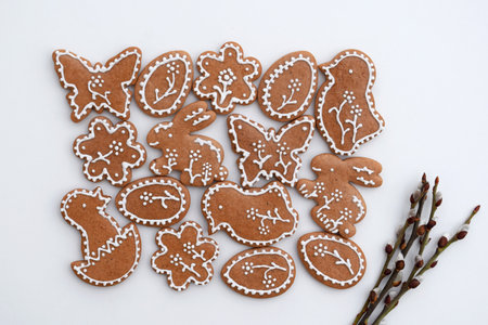 Romantic decorated Easter gingerbread cookies of various shapes and willow twigs on a white...