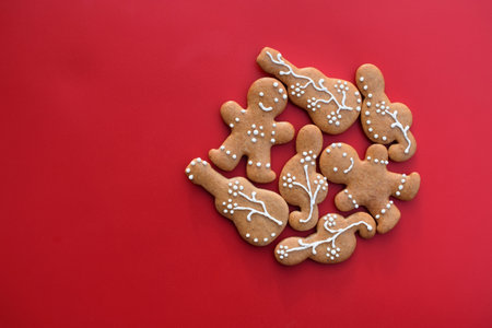 Decorated gingerbread cookies in a shape of guitar, treble clef and man, red background, copy space for text. Musical themeの写真素材