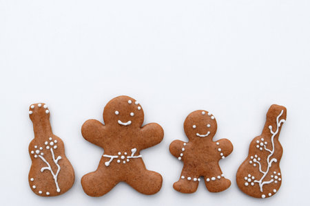Romantic decorated gingerbread cookies in a shape of guitar and man, white background, copy space for text. Musical themeの写真素材