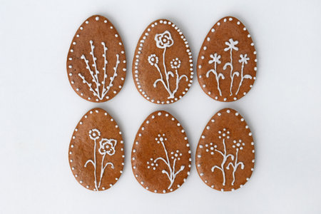 Romantic decorated Easter gingerbread cookies in a shape of egg, white background