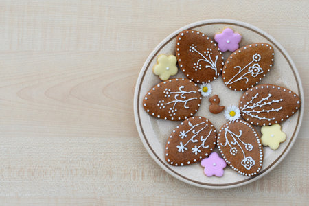 Plate with Easter gingerbread cookies of various shapes and flowers, copy space for textの写真素材