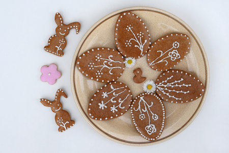 Plate with Easter gingerbread cookies of various shapes and daisy flowers