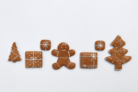 Decorated gingerbread cookies - trees, christmas presents and gingerbread man on a white background, copy space for textの写真素材