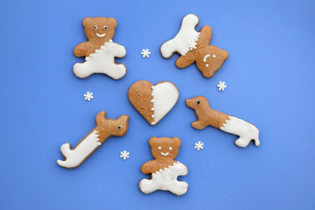 Cute gingerbread bears, dachshunds and heart on a blue background with snowflakesの写真素材