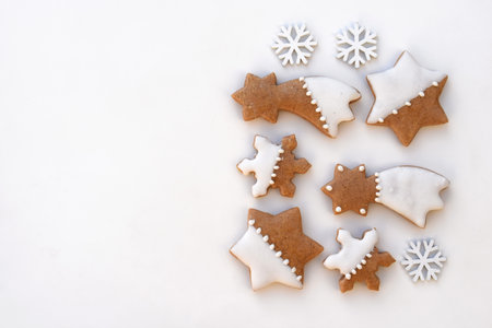 Decorated gingerbread cookies on a white background with snowflakes, copy space for textの写真素材