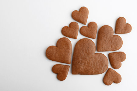 Undecorated heart-shaped gingerbread cookies in three sizes on a white background, copy space for textの写真素材