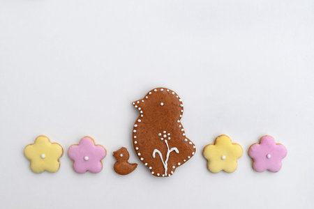 Romantic decorated Easter gingerbread cookies in a shape of chicken and flower, white background,...