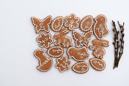 Romantic decorated Easter gingerbread cookies of various shapes and willow twigs on a white...