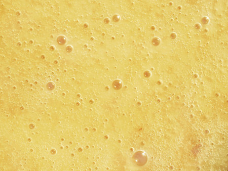 Fermented honey - honey with smell and taste, with many bubbles, flowing from a jar. Honey with high...