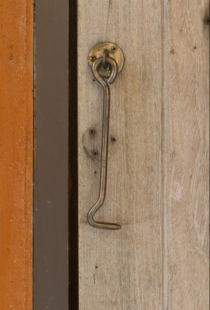 steel latch hanging on wooden wallの写真素材