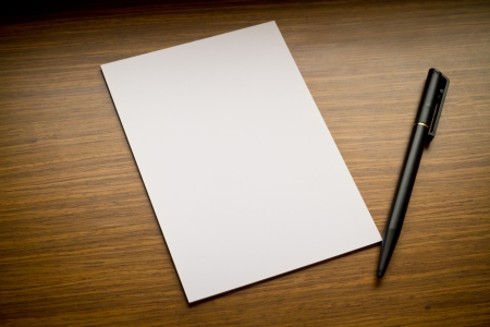 pen and white paper on wooden tableの写真素材
