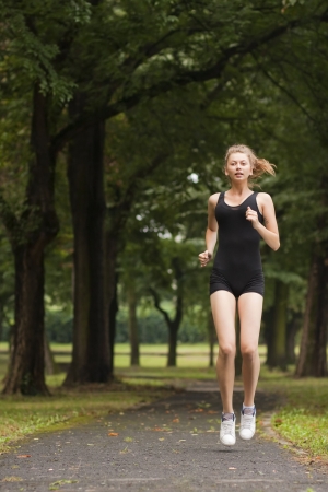 Pretty young girl running in the parkの写真素材