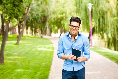 handsome man wlaking in the park on a sunny dayの写真素材