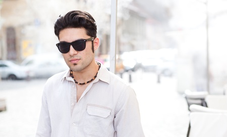 attractive man wearing sunglasses looking cool on the streetの写真素材