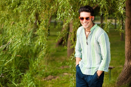 handsome man wearing sunglasses laughing in the parkの写真素材