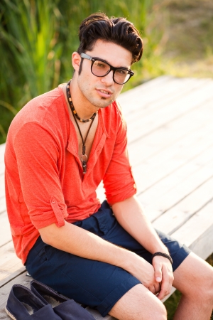 handsome man standing on a bridge by the lakeの写真素材