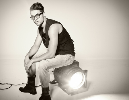 Sexy man doing a fashion photo shoot in a professional studioの写真素材
