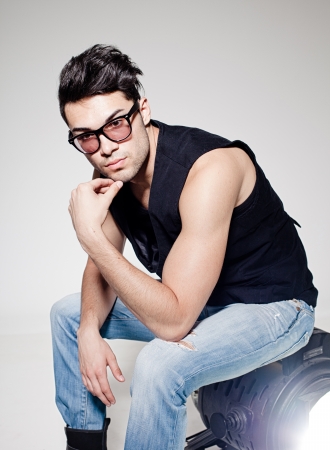 Sexy man doing a fashion photo shoot in a professional studioの写真素材