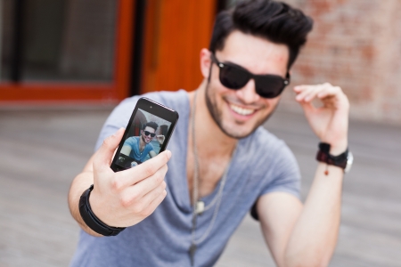 young male model making self portrait with a smartphoneの写真素材