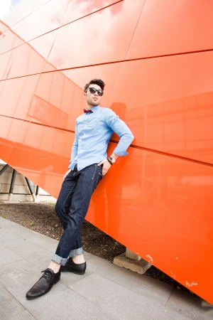 attractive young male model posing outdoors in blue shirt and sunglassesの写真素材