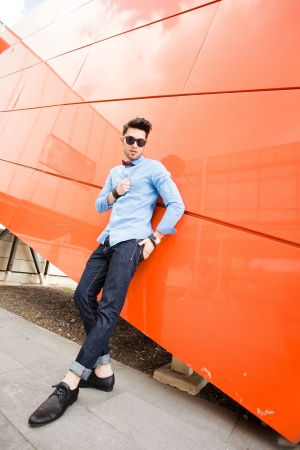 attractive young male model posing outdoors in blue shirt and sunglassesの写真素材
