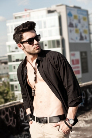 sexy man model unbuttoned shirt looking serious outdoorの写真素材