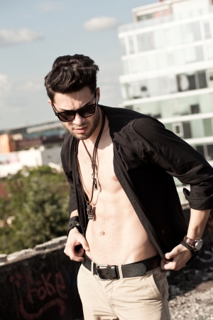 sexy man model unbuttoned shirt looking serious outdoorの写真素材