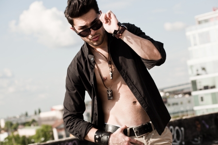 attractive man with unbuttoned shirt looking serious の写真素材