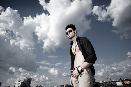 attractive man with unbuttoned shirt looking serious の写真素材